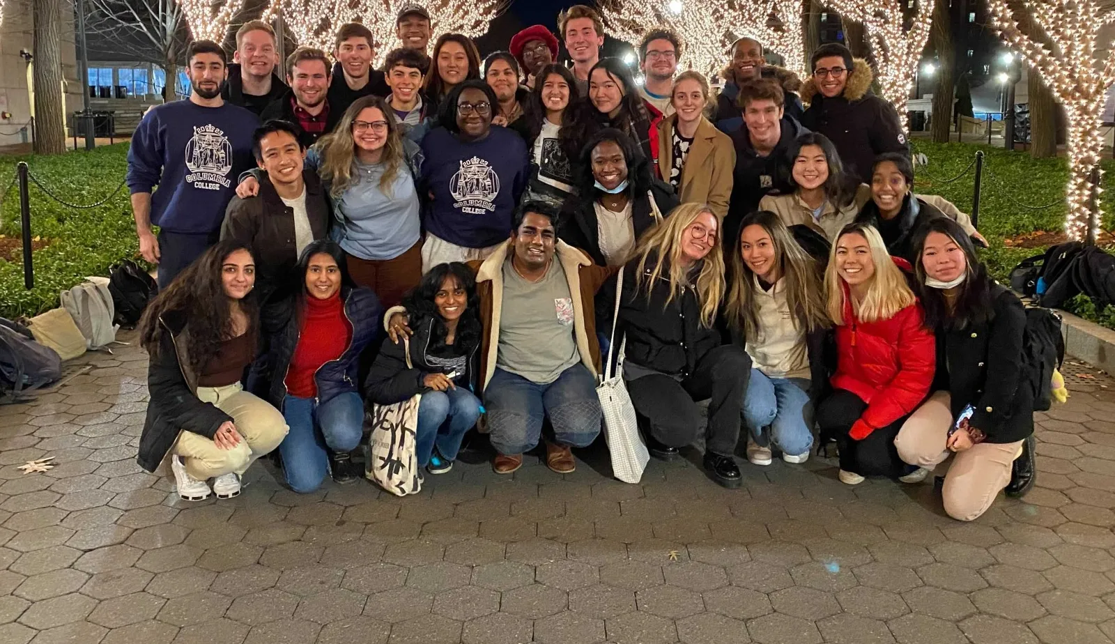 Picture of the student council on college walk, with trees lit. 
